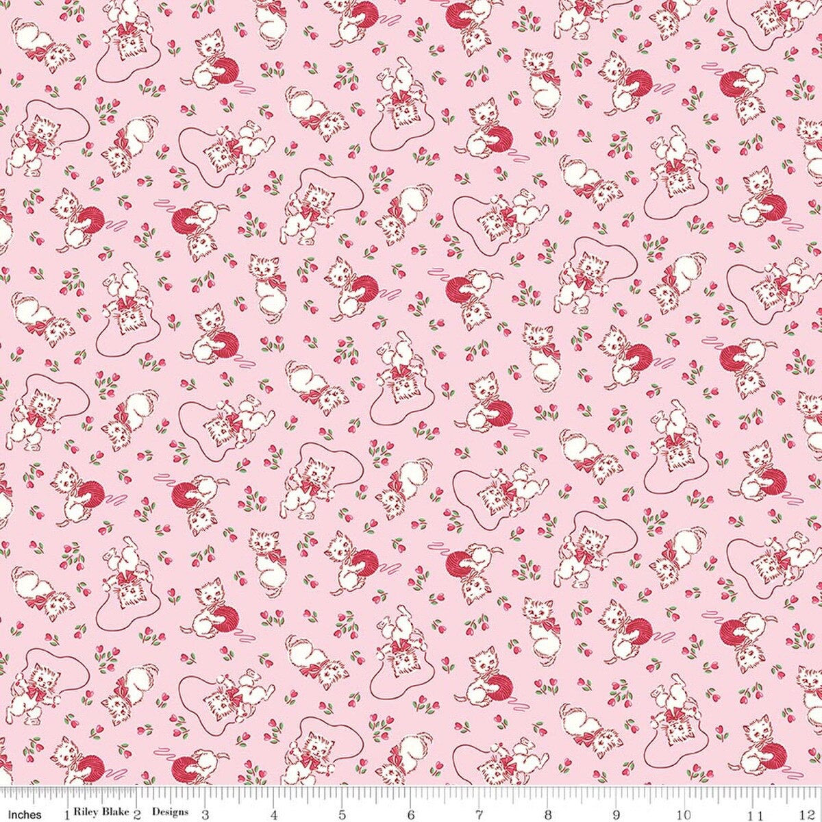 Pink fabric with a vintage kitten playing with yarn a jump rope and scattered flowers throughout