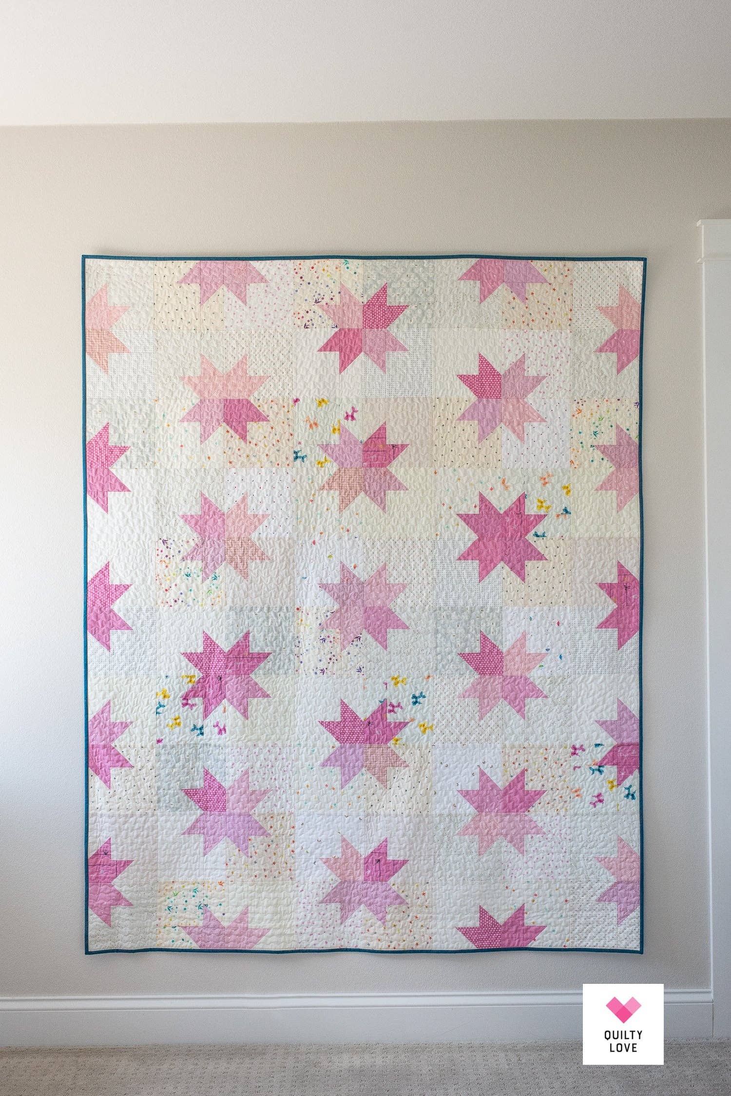 Quilt with pink star pattern on a plain background