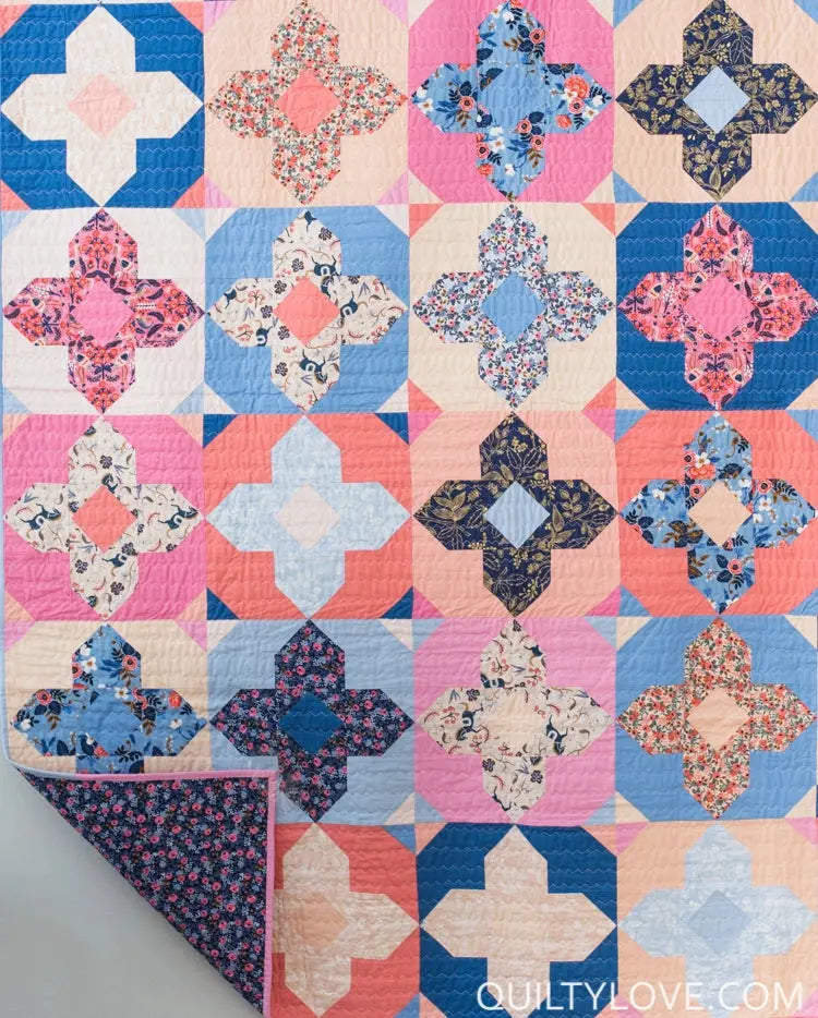 Colorful quilt with floral patterns on a plain background