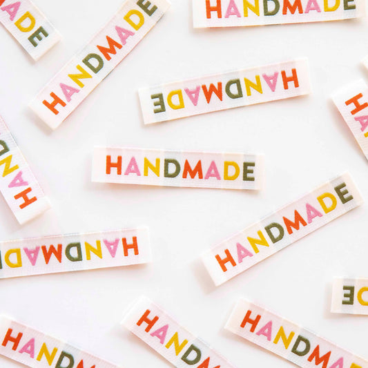 Colorful 'HANDMADE' labels scattered on a white background