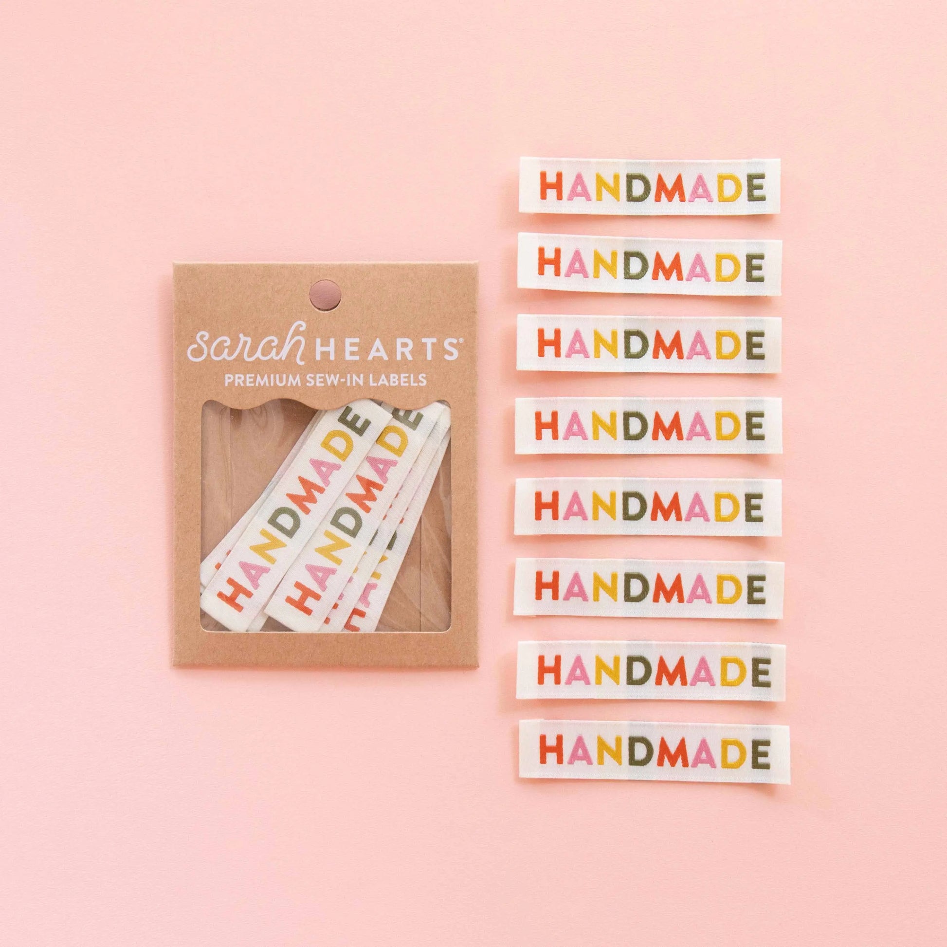 Packaging of 'Handmade' labels by Sarah Hearts on a pink background