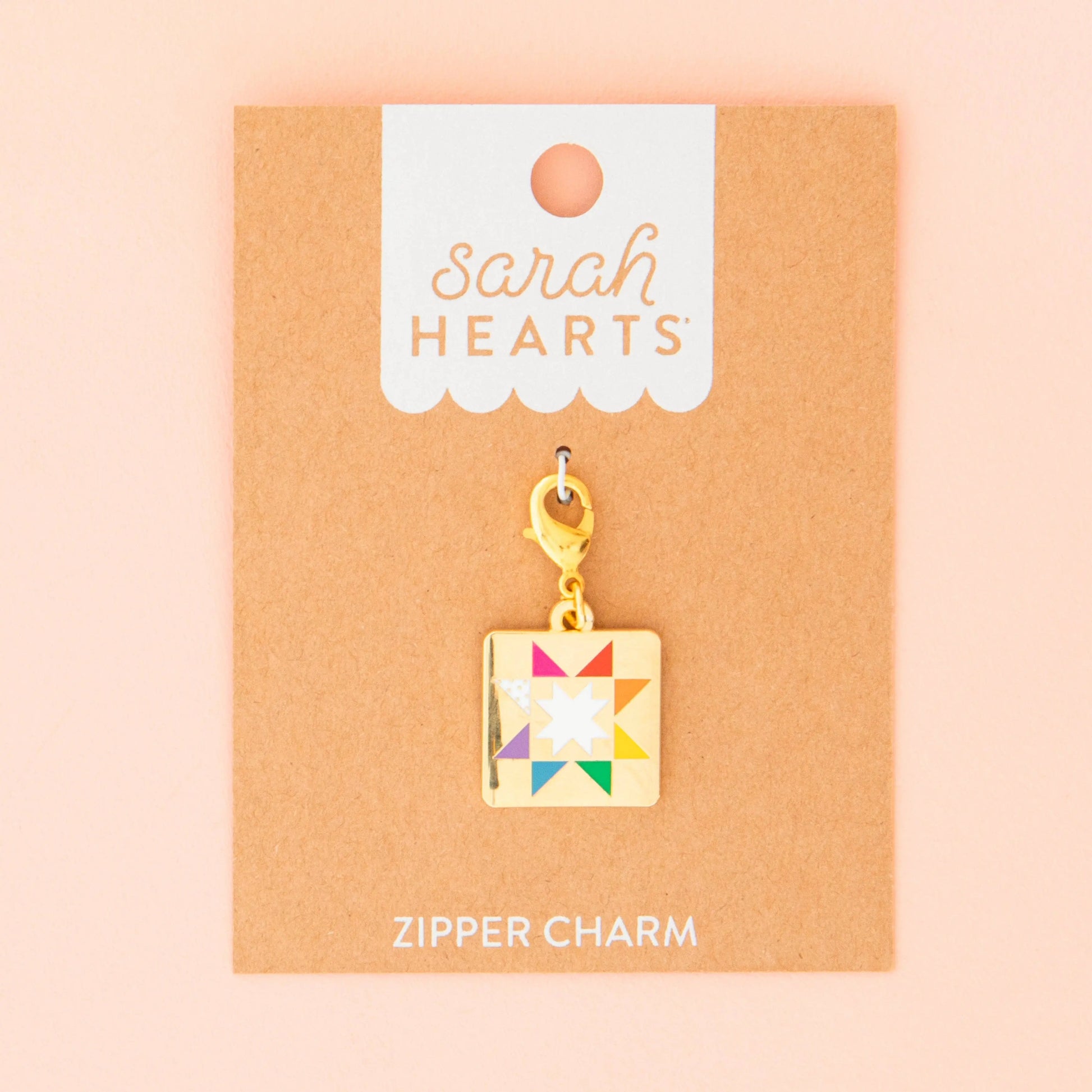 Colorful quilt zipper pull charm on a 'Sarah Hearts' branded card with a pink background