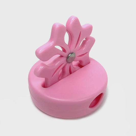 Pink flower-shaped thread cutter on a white background