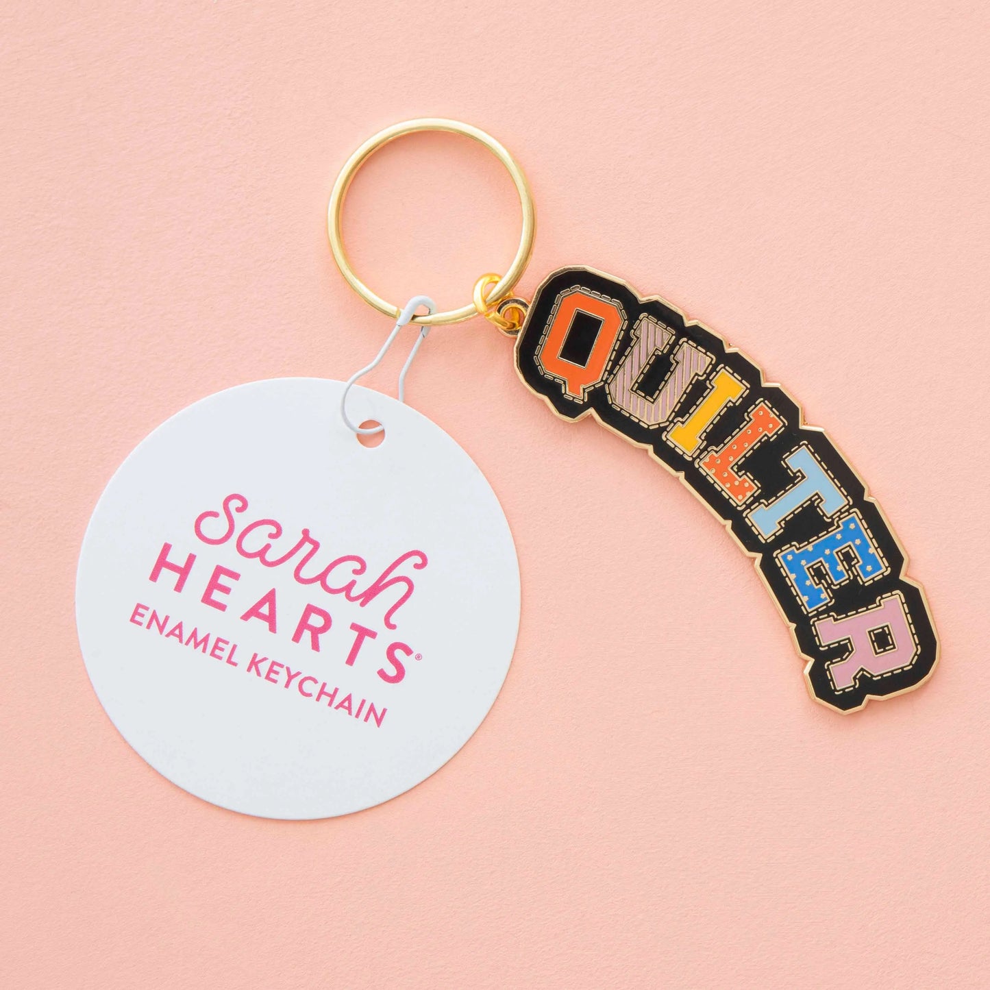 Keychain with 'Quilter' enamel design on a pink background