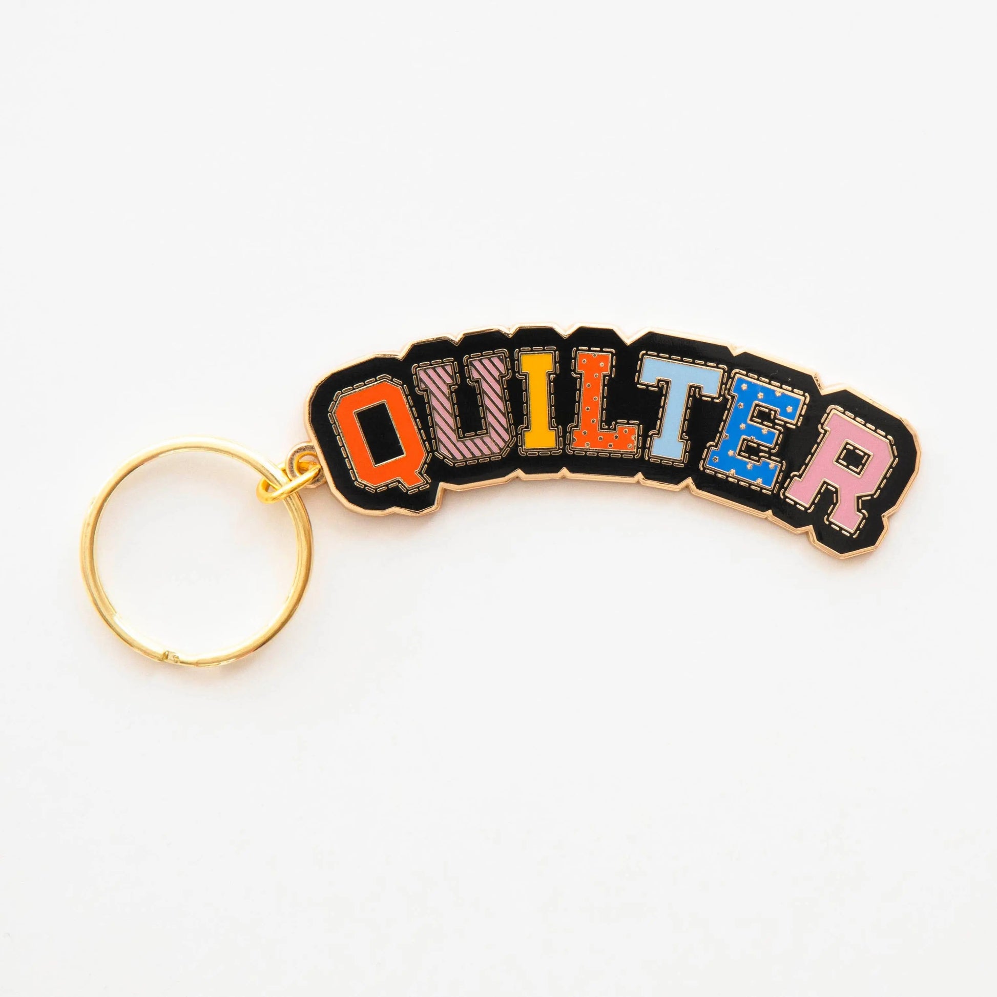 Keychain with 'QUILTER' in colorful letters on a white background