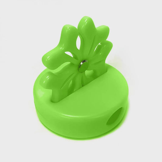Green plastic tool with a circular base and leaf-like top on a white background