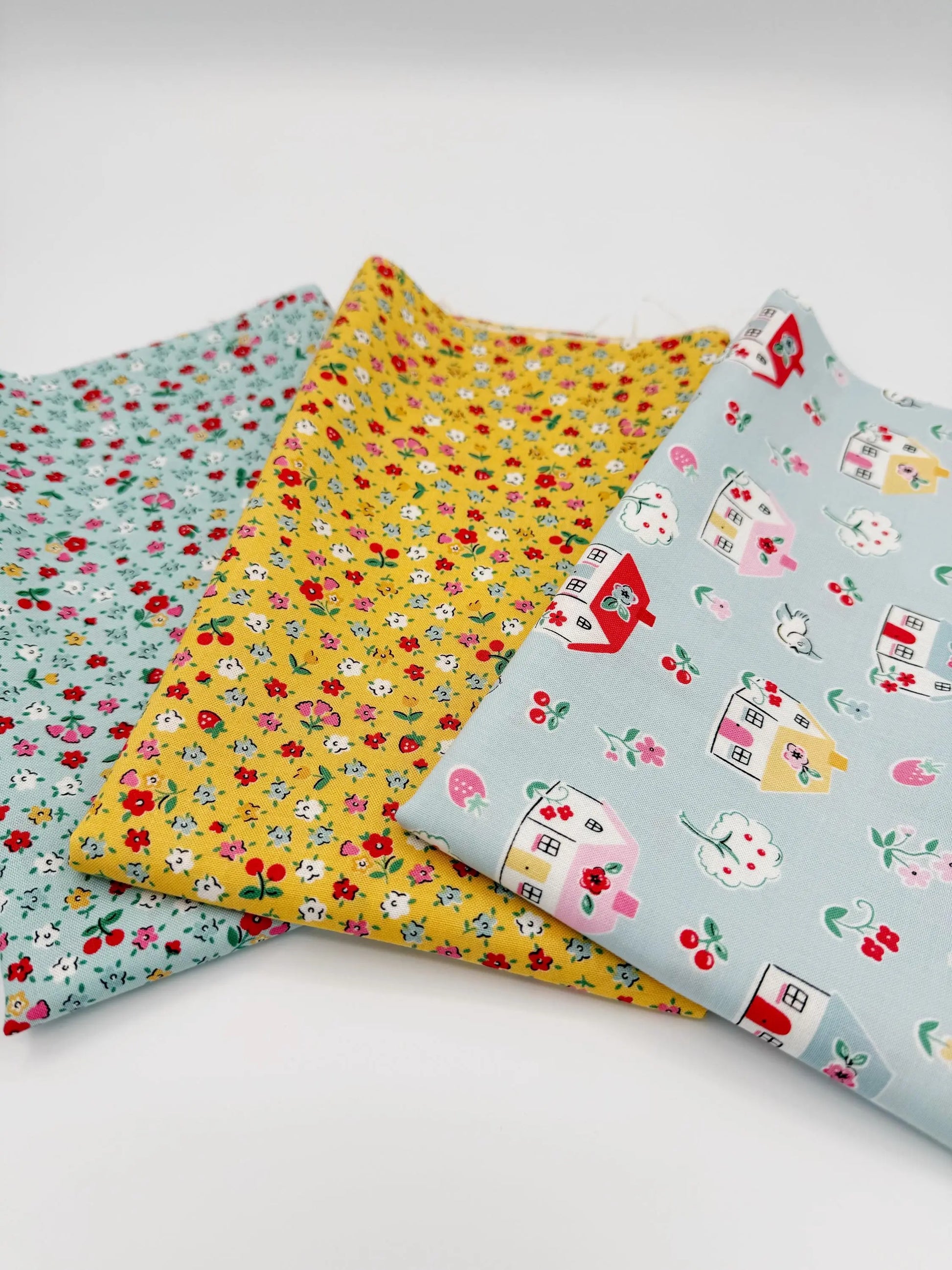 Three pieces of fabric with different patterns on a white background