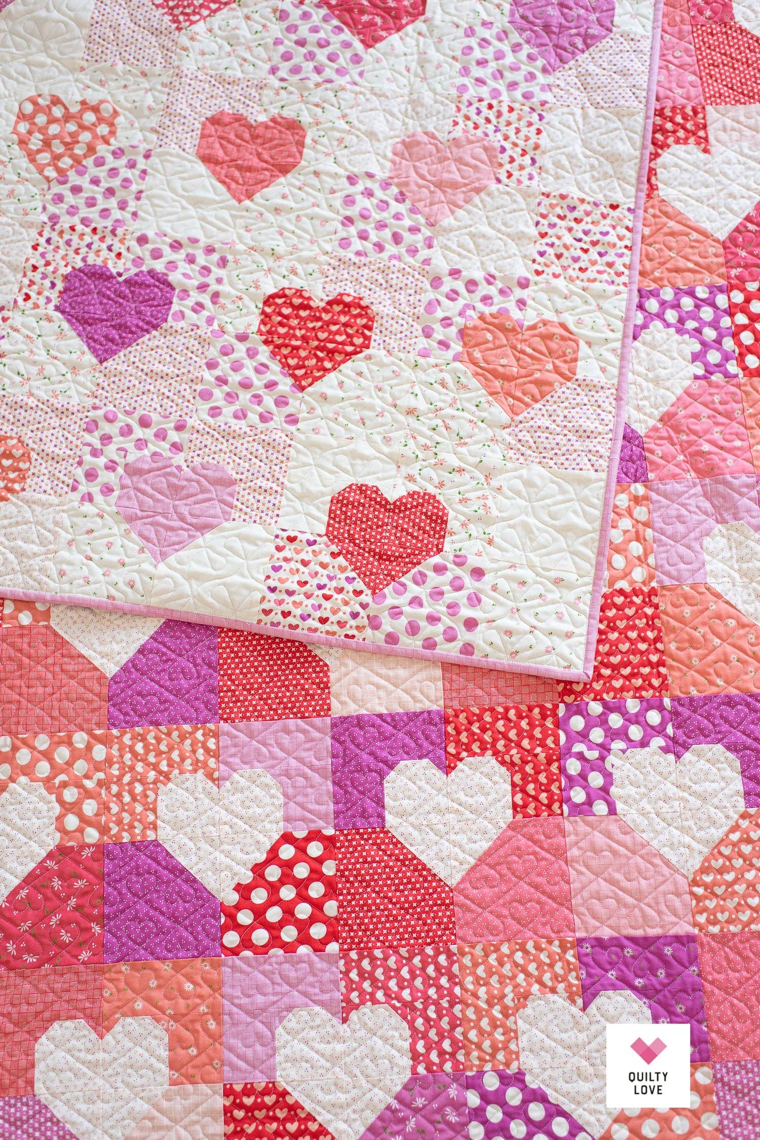 Quilt with heart patterns in various colors on a white background