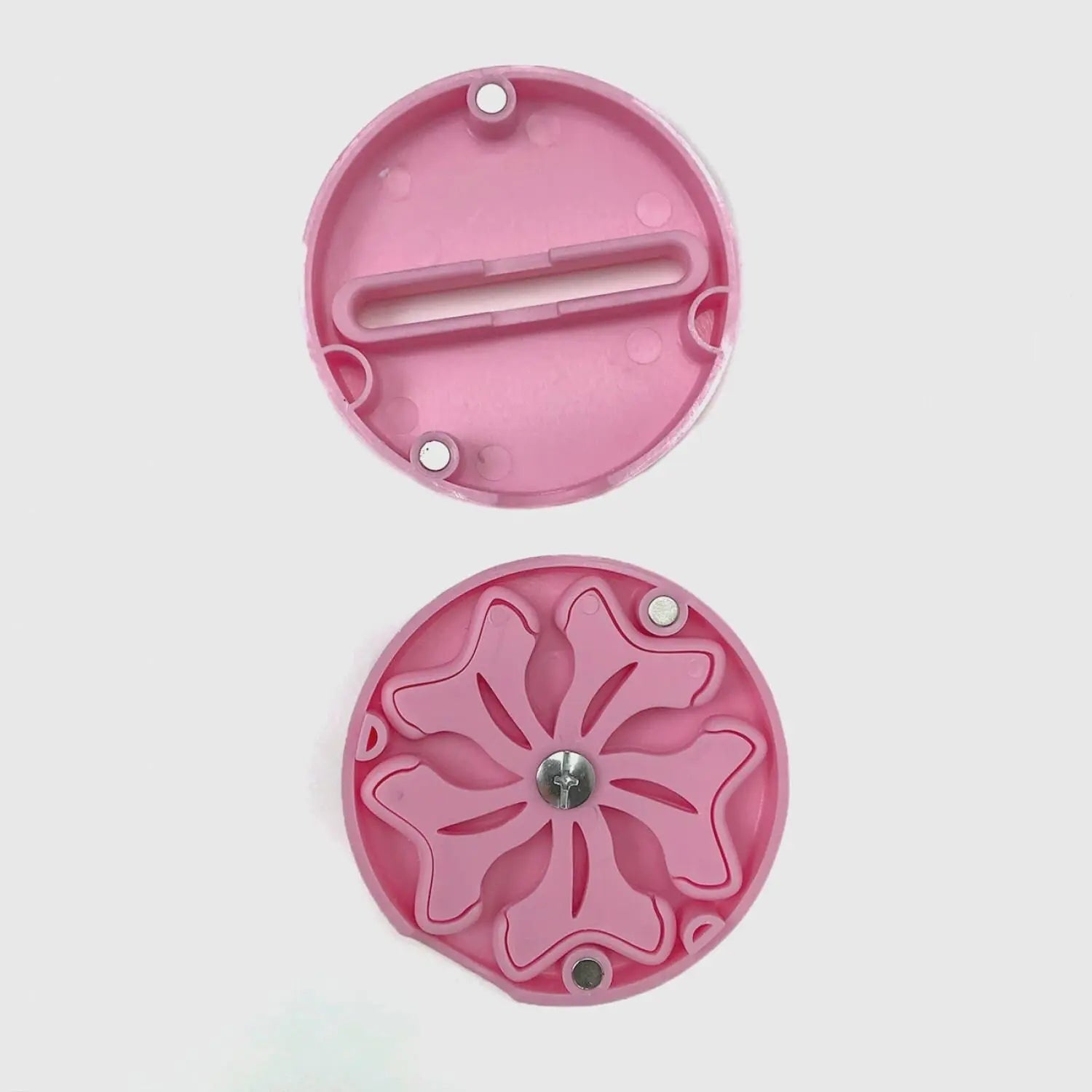 Two pink plastic components on a light gray background