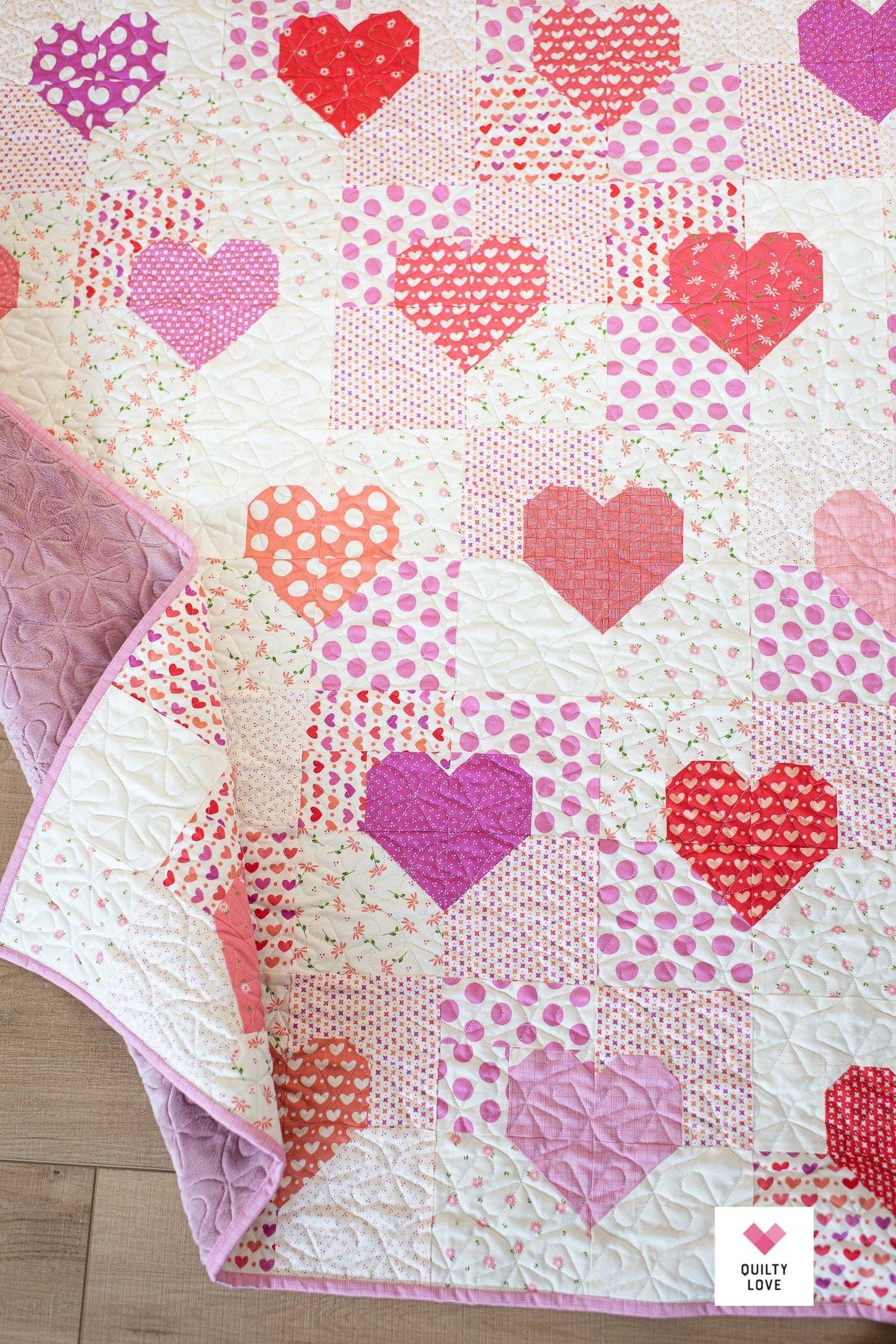 Quilt with heart patterns on a wooden surface