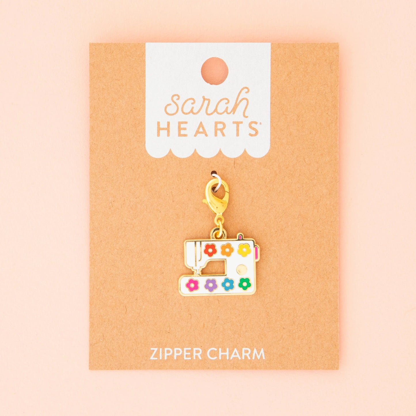 Sewing machine zipper charm on a 'Sarah Hearts' branded card with a pink background