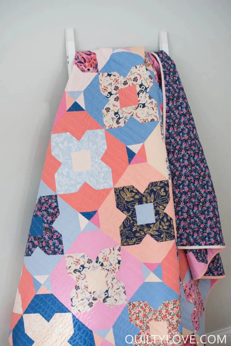 Colorful quilt with geometric patterns on a white background