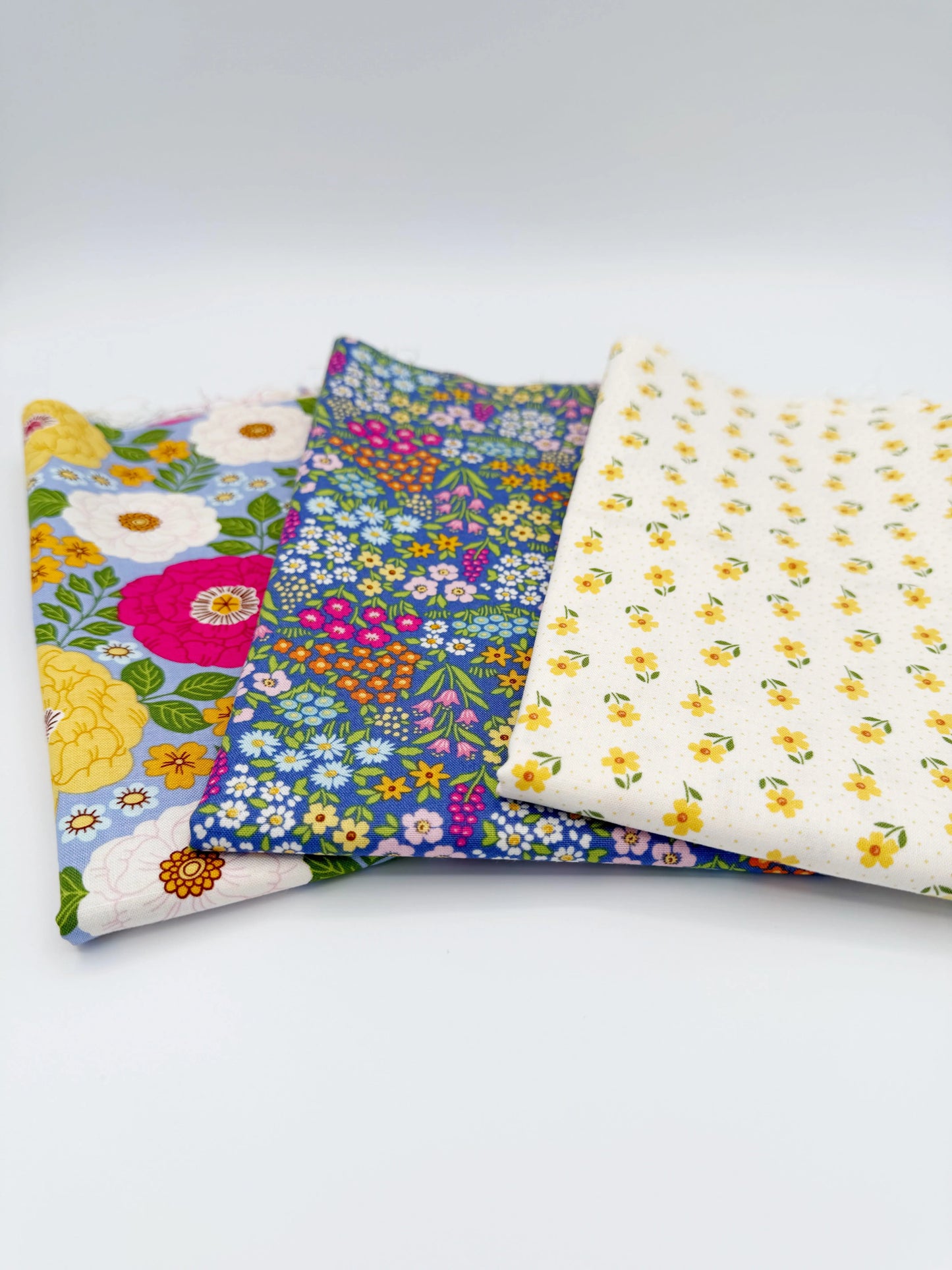 Three fabric swatches with floral patterns on a white background