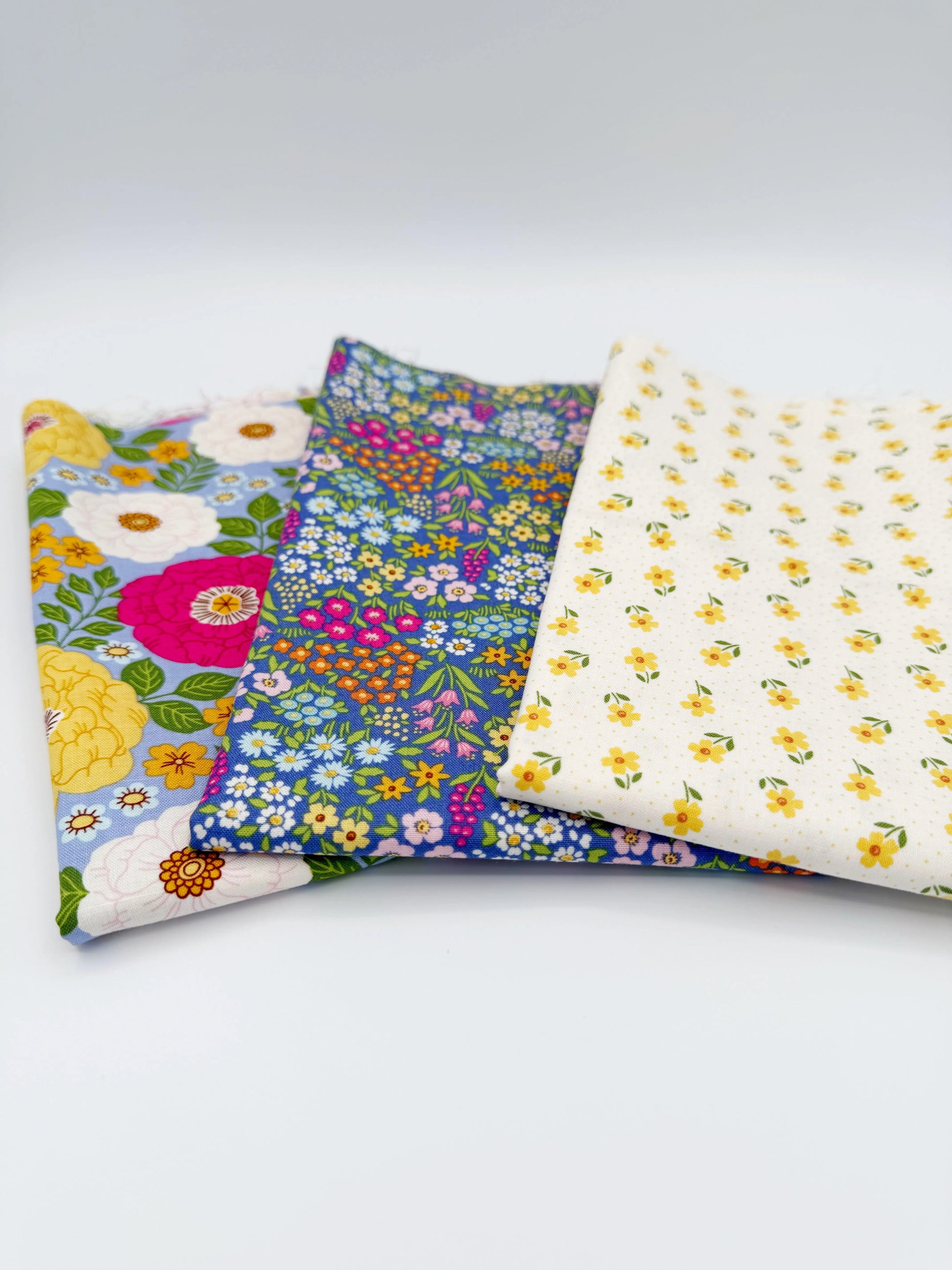 Three fabric swatches with floral patterns on a white background