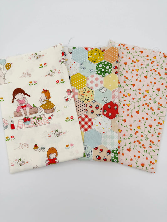 Three fabric swatches also known as a fat quarter bundle with different patterns on a white background