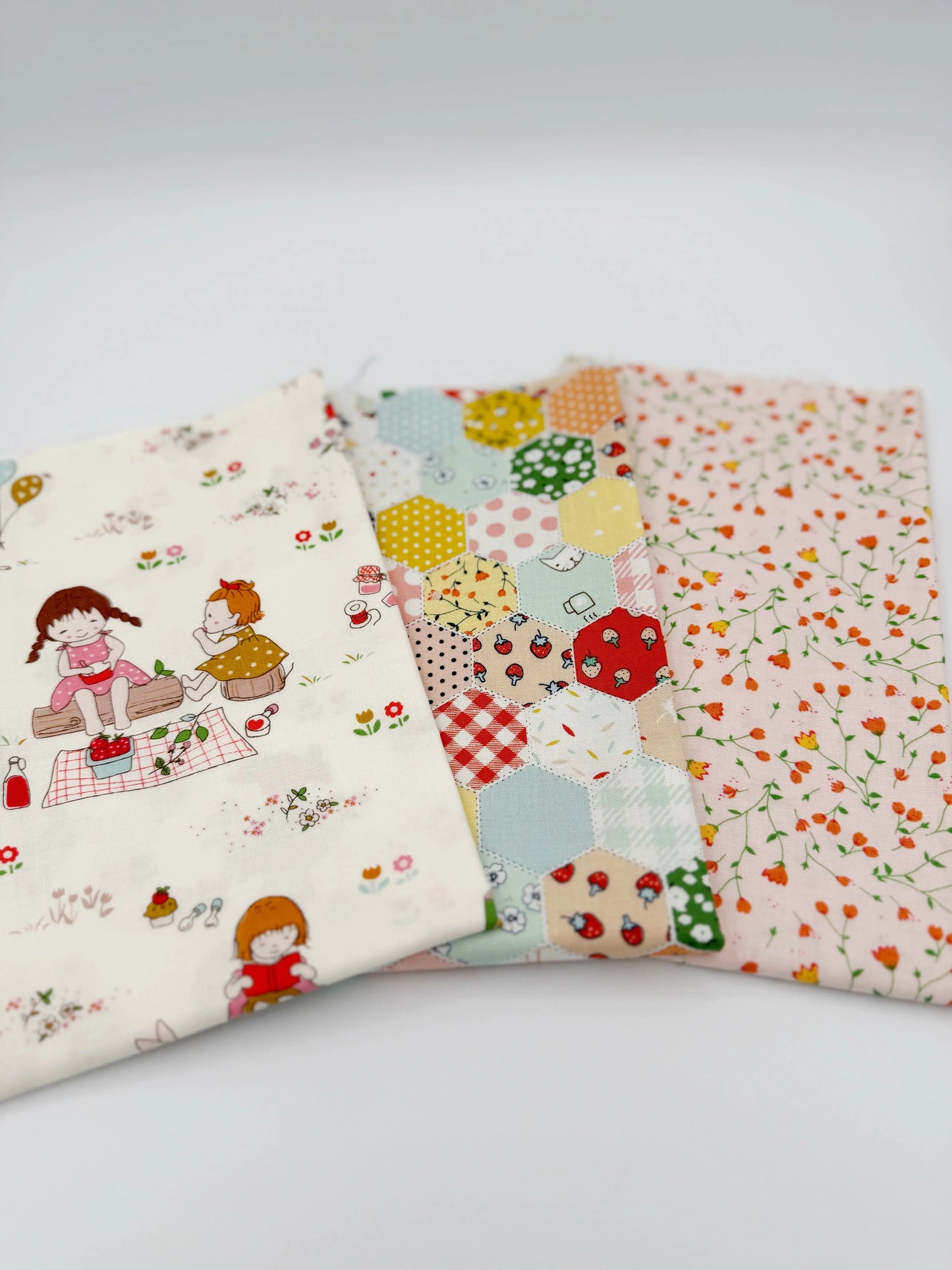 Three pieces of colorful fabric with cartoon designs on a white background