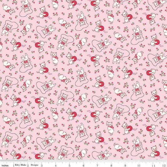 Pink fabric with a vintage kitten playing with yarn a jump rope and scattered flowers throughout