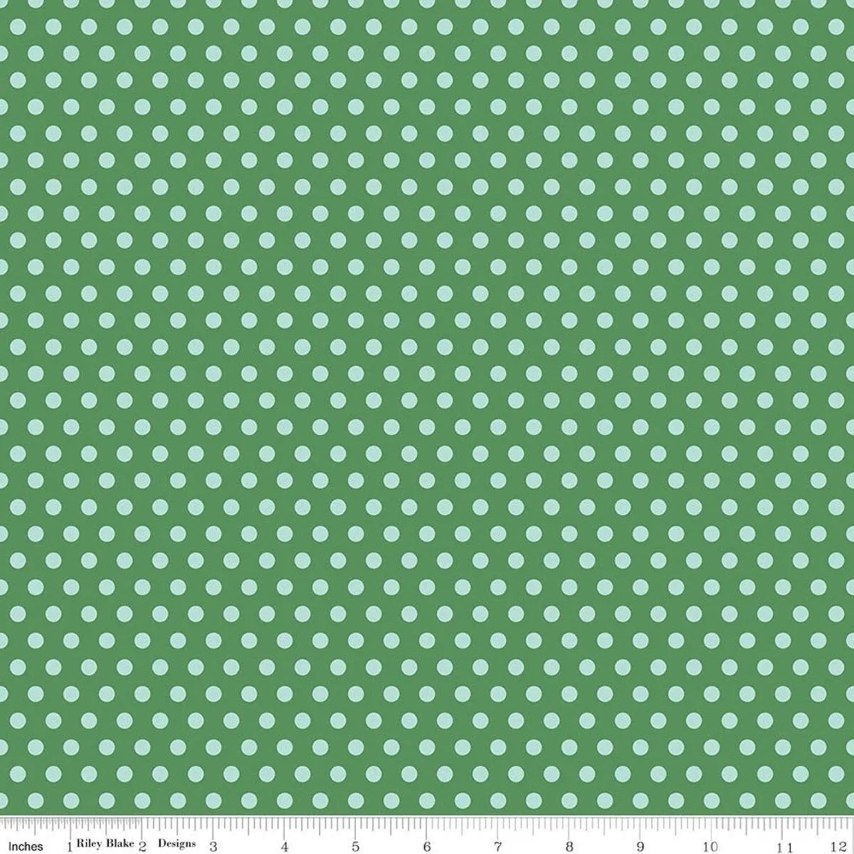 Green fabric with light blue polka dots and a ruler at the bottom.