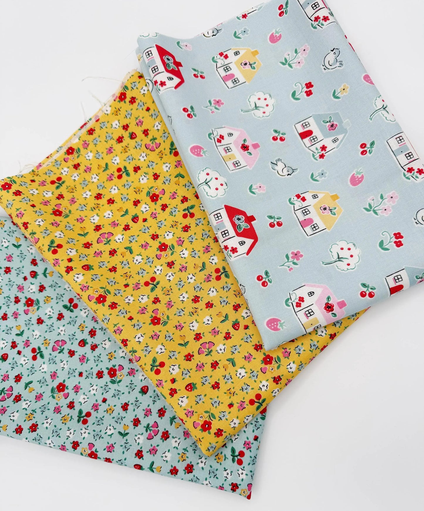 Three pieces of fabric with different patterns on a white background