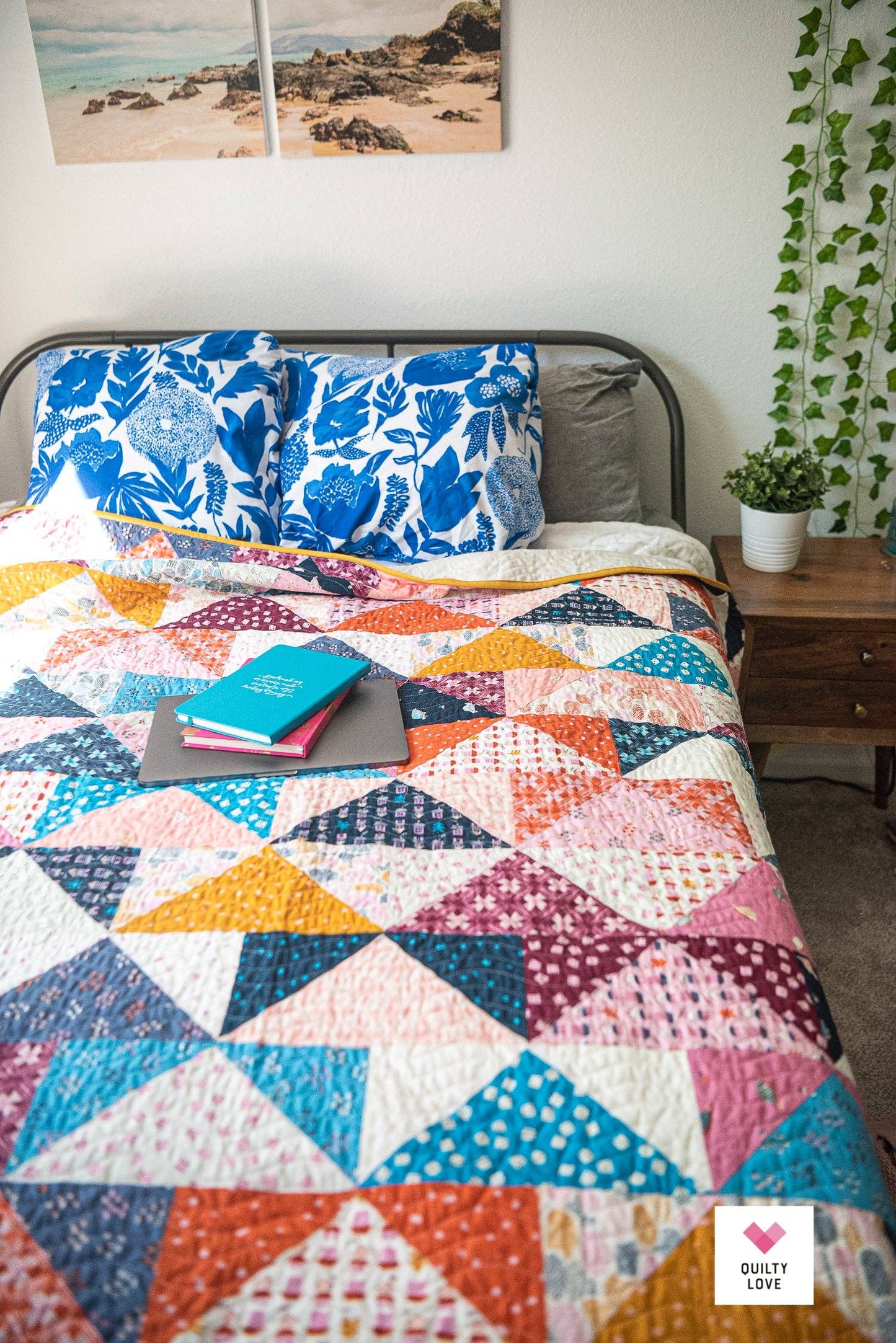 Colorful quilt with geometric pattern on a bed in a bedroom setting.