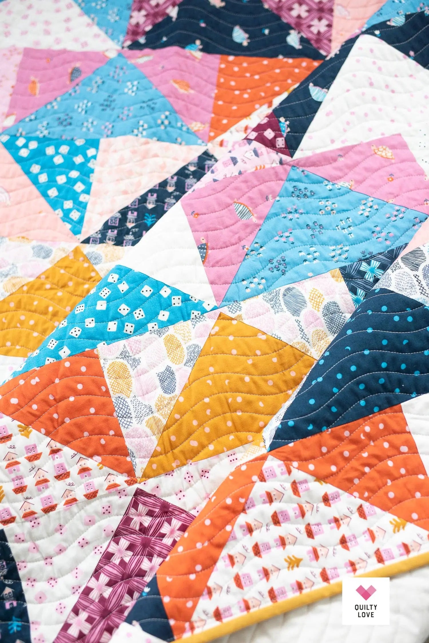 Colorful quilt with geometric patterns on a white background