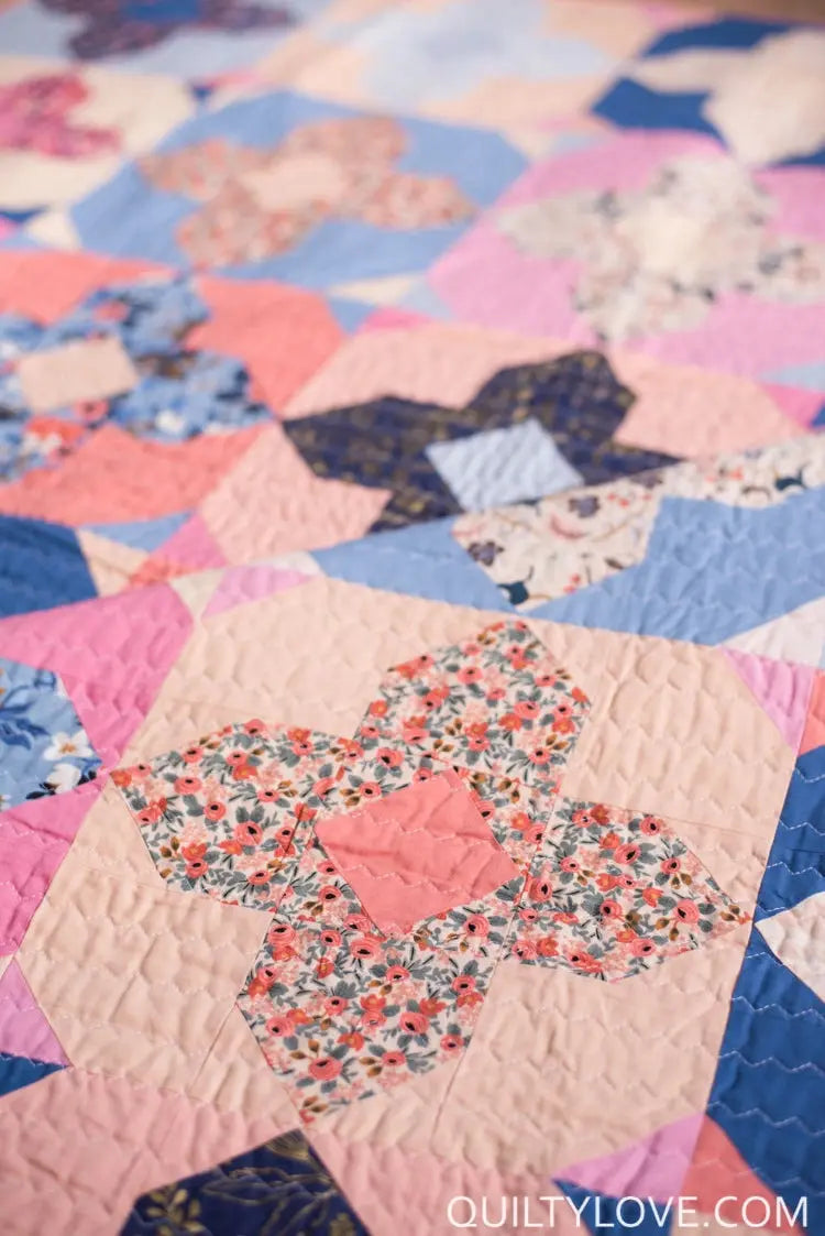 Close-up of a patchwork quilt with floral patterns on a colorful background