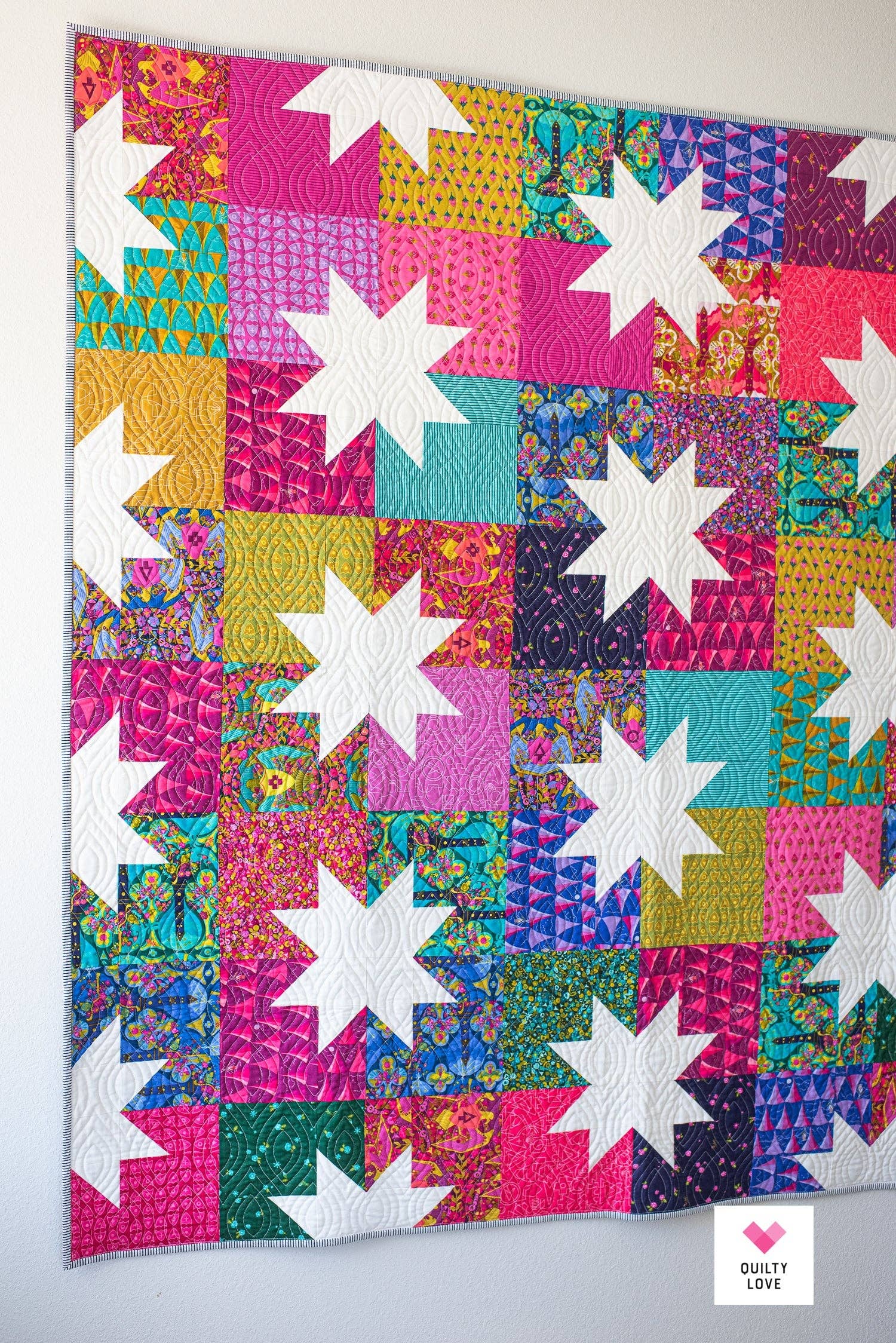 Colorful quilt with star patterns on a white background